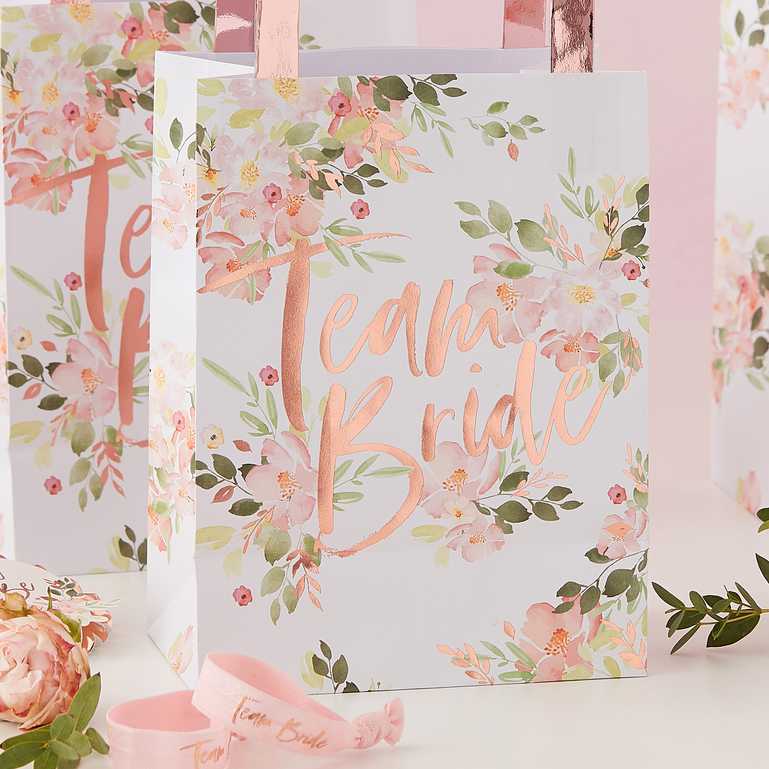 floral flower design paper party gift treat bags with the words 'team bride' in rose gold printed on them for bridal showers, hens parties or bachelorette parties