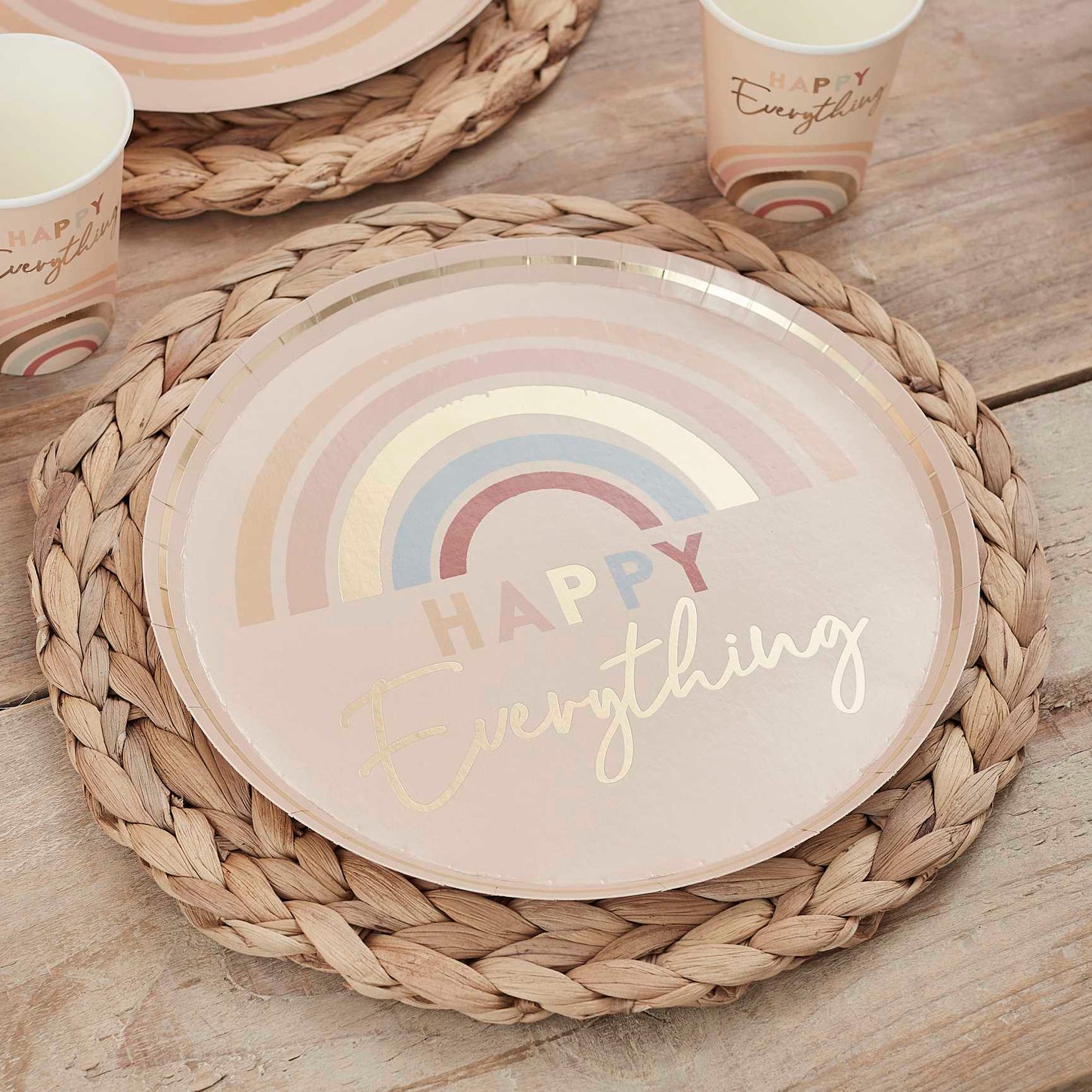 muted pastel tones paper party plates that read the words 'happy everything' on them with pastel rainbow designs for a joyful happy birthday party theme