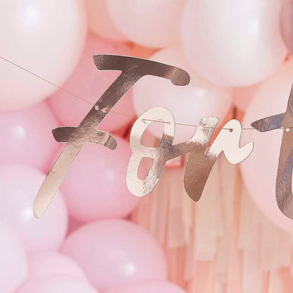 Rose gold wording banner that says 'forty' for a 40th birthday party decoration