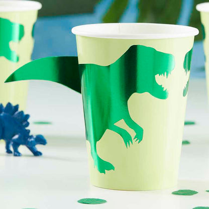 green dinosaur paper party cups with a 3d pop out dinosaur tail for a kids dinosaur birthday party theme decoration