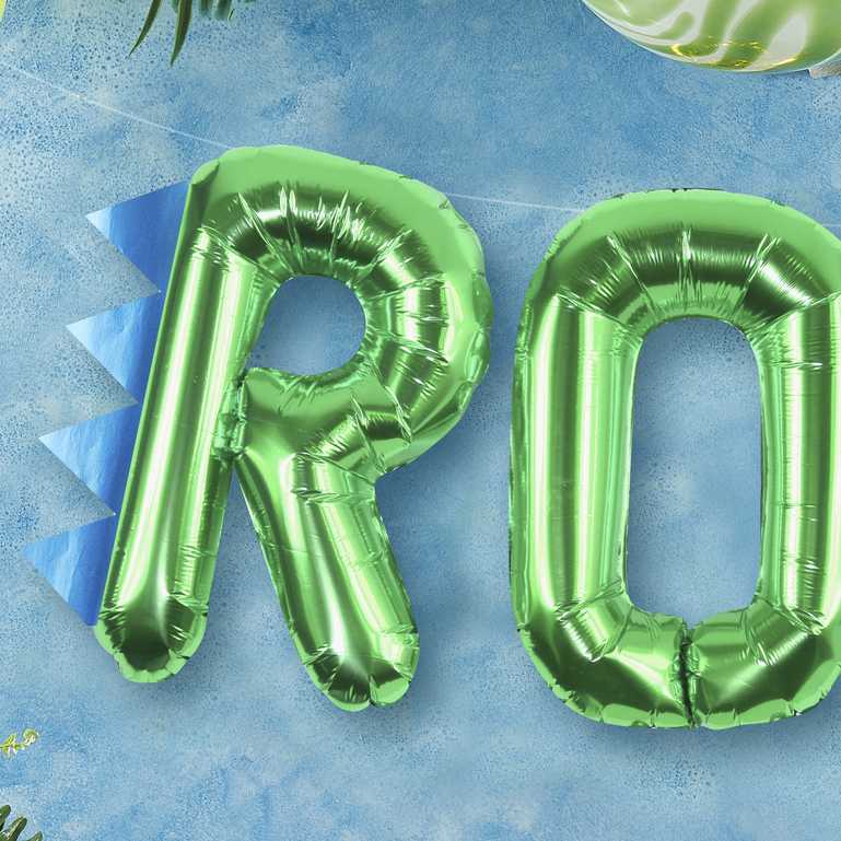 Green foil balloons that read the words "ROAR' for a kids dinosaur birthday party theme decoration