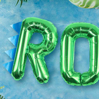 Green foil balloons that read the words "ROAR' for a kids dinosaur birthday party theme decoration