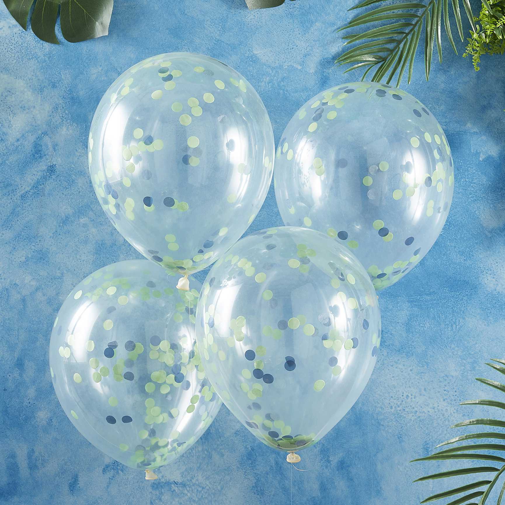 clear balloons with green and blue paper confetti on the inside for a kids dinosaur birthday party theme decorations