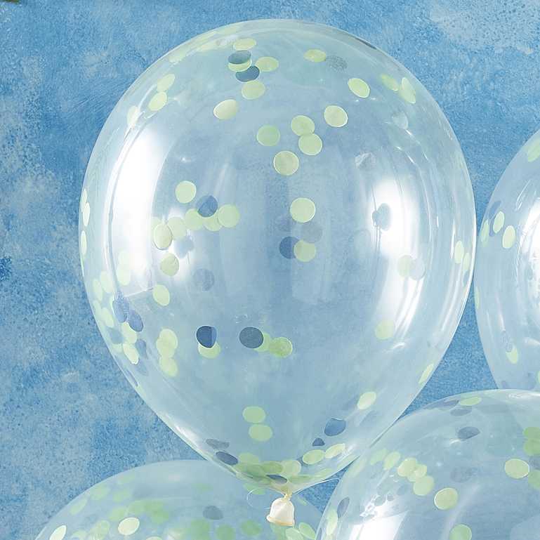 clear balloons with green and blue paper confetti on the inside for a kids dinosaur birthday party theme decorations