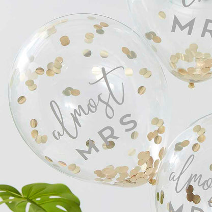 clear balloons fileed with gold confetti with the writing 'almost mrs' written on them for bridal showers, hens party or bachelorette gold theme party decorations