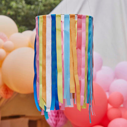 hanging hoops from the ceiling with rainbow multicoloured ribbon streamers hanging from them for party decorations