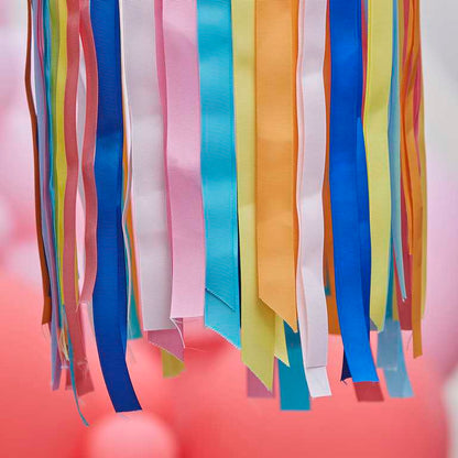 hanging hoops from the ceiling with rainbow multicoloured ribbon streamers hanging from them for party decorations