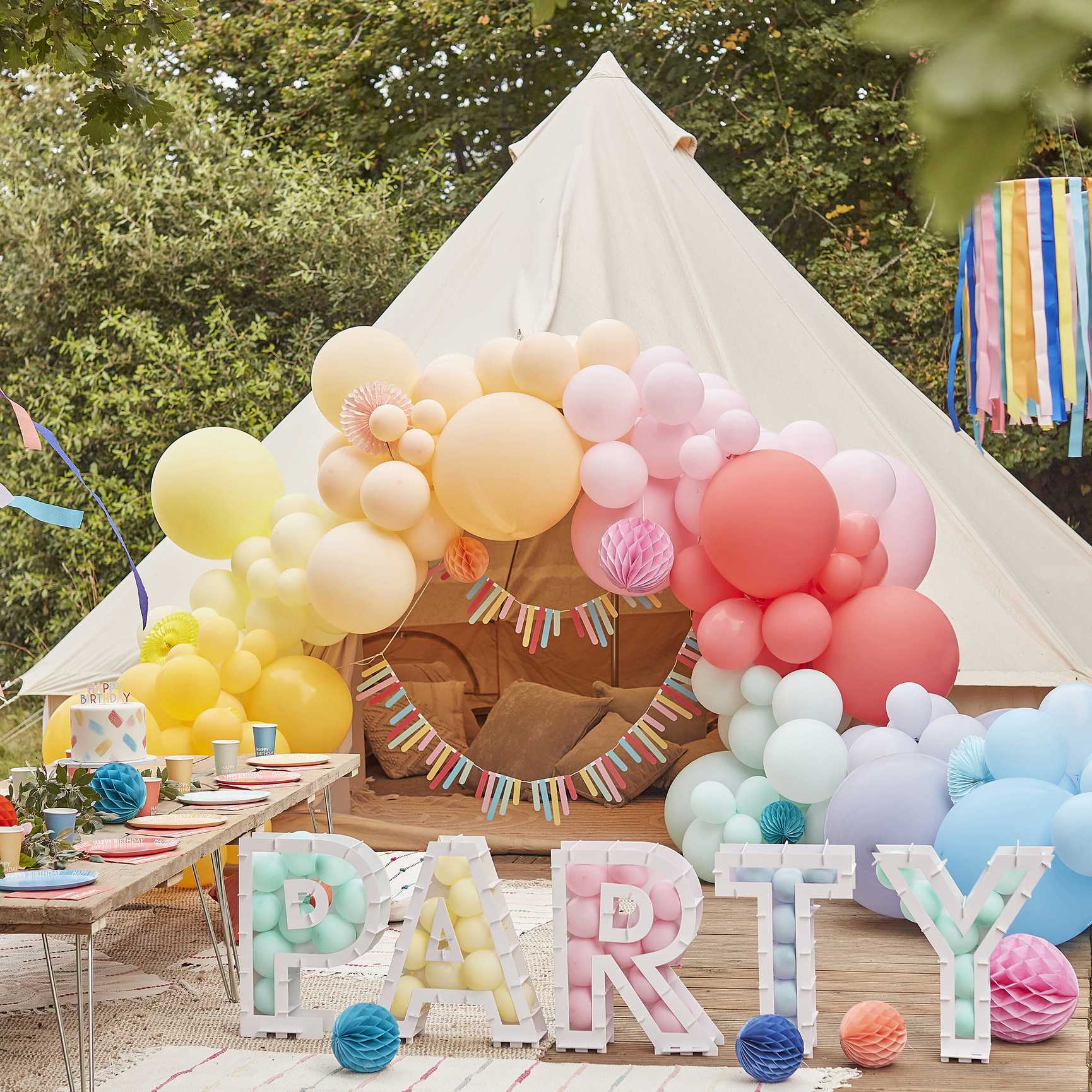 hanging hoops from the ceiling with rainbow multicoloured ribbon streamers hanging from them for party decorations