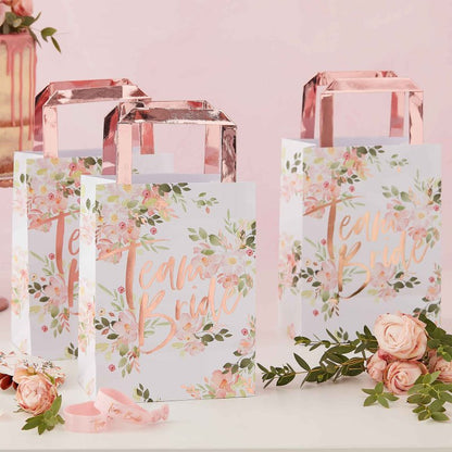 floral flower design paper party gift treat bags with the words 'team bride' in rose gold printed on them for bridal showers, hens parties or bachelorette parties